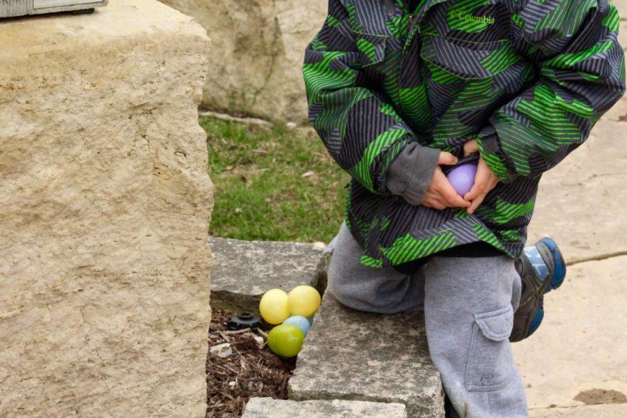 A child fills his pockets with eggs at Reiman Gardens March 26. The annual Easter egg hunt included children in 6th grade and under.