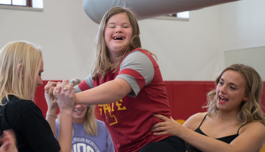 A member of the Iowa State Sparkles Squad is lifted by the clubs co-presidents, Hali Weimerskirch, senior in early childhood education and Mara Mapes, sophomore in child, adult and family services. 