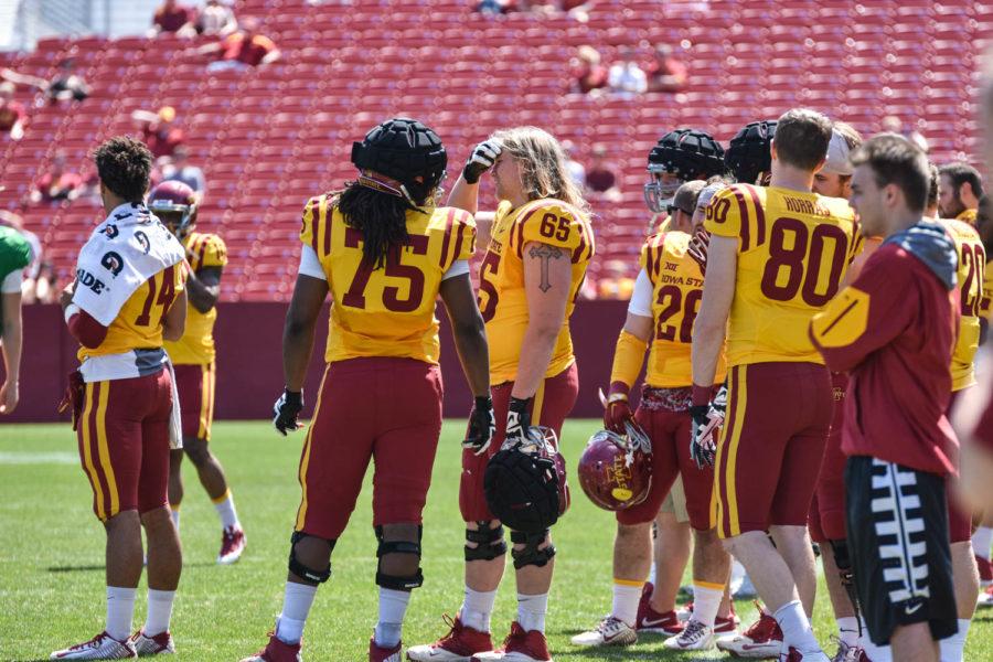 Iowa State offensive linemen Breion Creer (75) and Karson Green (65) watch as the Gold Team falls behind in the spring football game on April 16. The Cardinal Team won 10-6. Green was a spring recruit this season and chose ISU over Middle Tennessee State, New Mexico, Houston and East Carolina.