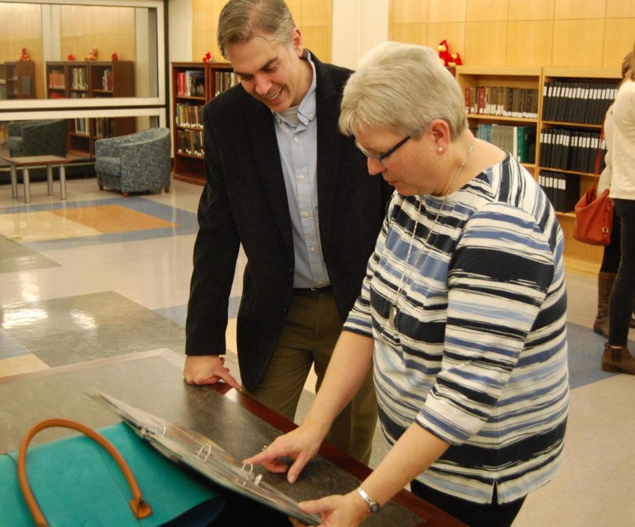 Iowa State history professor Mark Barron and former Pammel Court resident Carole Kettwick look through a scrapbook of photos from other former Pammel residents. An exhibit, titled For Married Students:Building a Community in Pammel Court, 1946-1978, opened Wednesday, Jan. 18 in Special Collections.