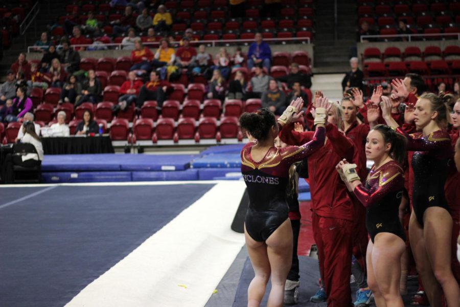 Hilary Green celebrates with her teammates after her floor routine on Jan. 13 in Hilton Coliseum during Iowa State gymnastics tri-meet on Jan. 13. Iowa State won the tri-meet against Towson and UW-Oskosh with a score of 194.275.