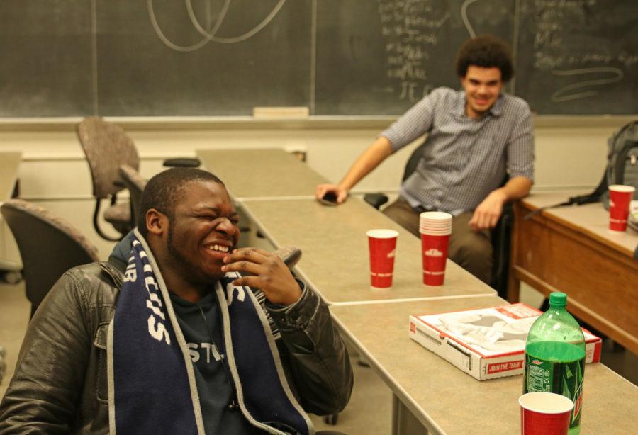 Sophomore Josh Popoola laughs as another student presents jokes at an Iowa State Stand-Up Comedy Club meeting.