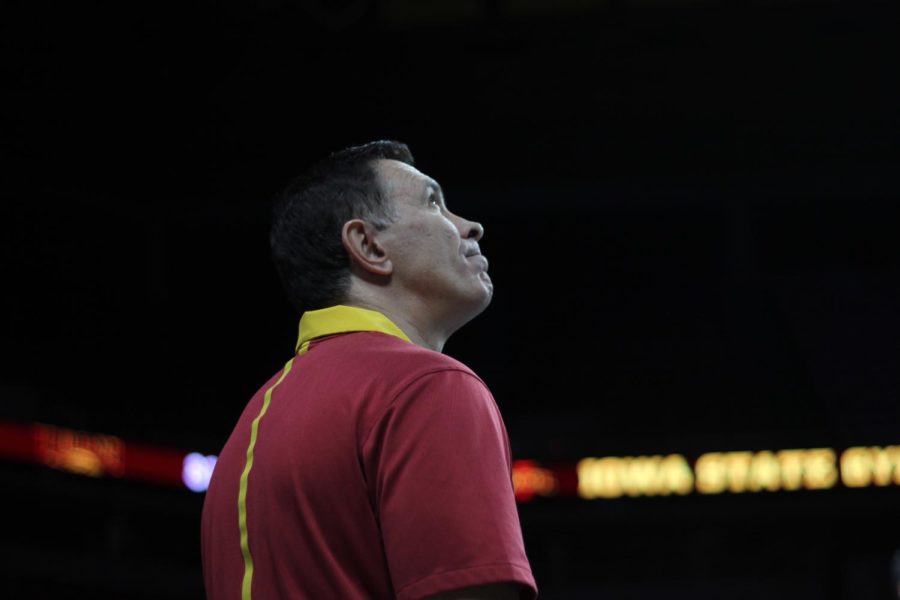 Assistant Coach Nilson Savage looks at the scoreboard on Jan. 13 in Hilton Coliseum during Iowa State gymnastics tri-meet on Jan. 13. Iowa State won the tri-meet against Towson and UW-Oskosh with a score of 194.275.