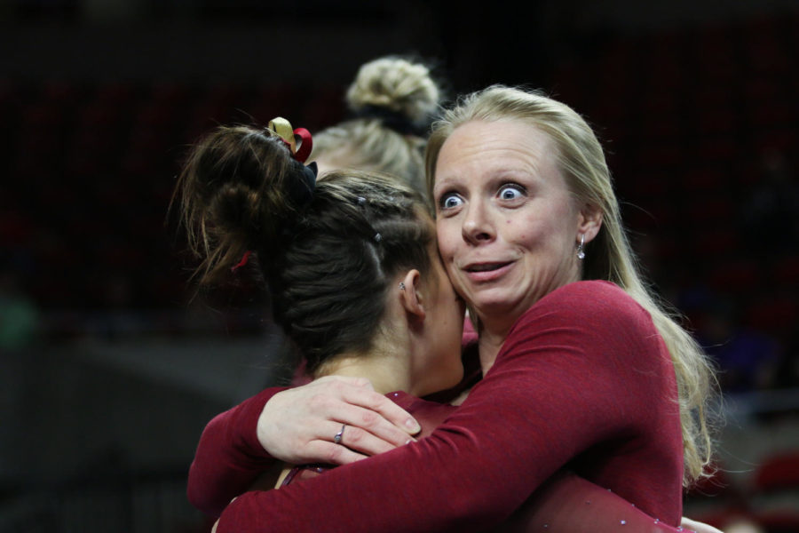 Assistant gymnastics coach Katie Minasola reacts after Meaghan Sievers beam routine Feb. 17. 