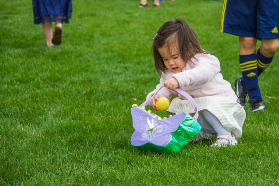 A child puts an egg in her basket during the annual Ames Jaycees Easter Egg Hunt, Saturday in Reiman Gardens. In addition to the egg hunt, children and their families could participate in bag races, bubble blowing, and various other activities around the garden. 