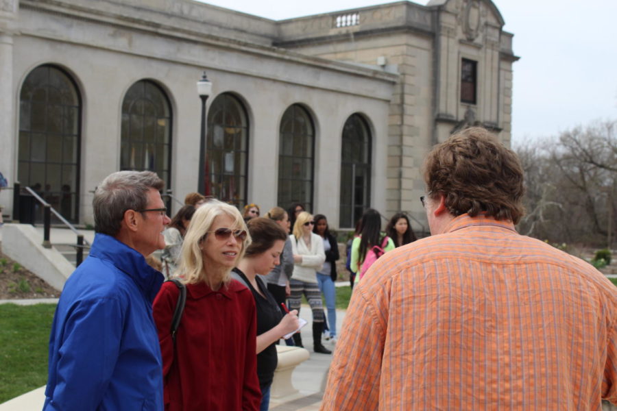 David Faux (right) speaks about how poetry influenced Christian Peterson in his creation of the Fountain of the Four Seasons outside of the Memorial Union during an art walk on April 12. Led by Faux, the art walk focused on how poetry affected the different works of art on campus, such as the statue of Carver and the Fountain of the Four Seasons. 