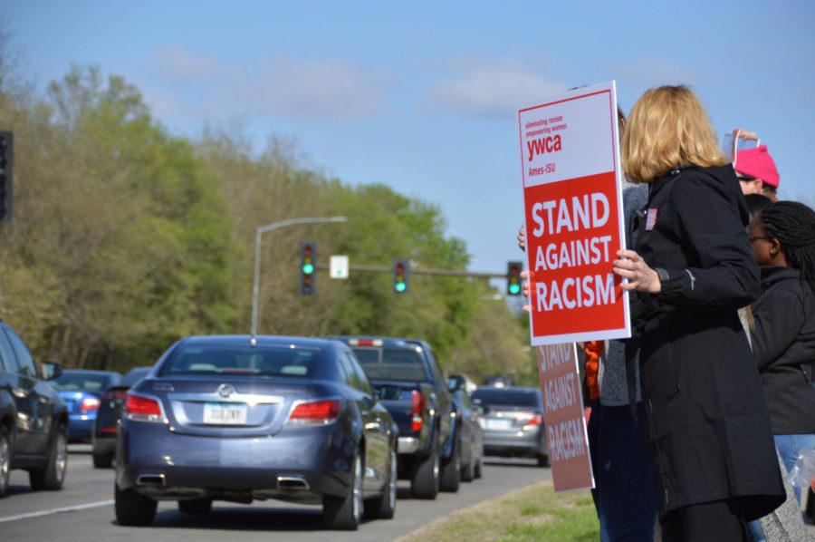 A peaceful protester stands on Lincoln Way with members of the Ames-ISU YWCA for a peaceful stand of unity against racism on April 27. YWCA is on a mission to eliminate racism, empower women, stand up for social justice, help families, and strengthen communities. 