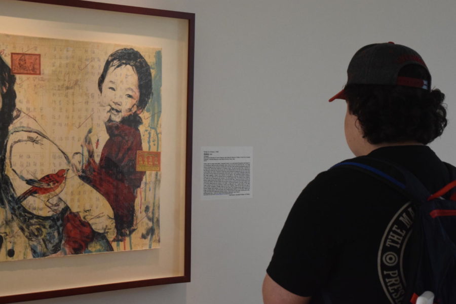 A student wanders through the Christian Petersen Art Museum, listening to the conversation of Art + Issues. University Museums holds Art + Issues to celebrate the diversity of our cultural heritage, teach critical thinking and generate dialogue that helps to build an inclusive campus community.