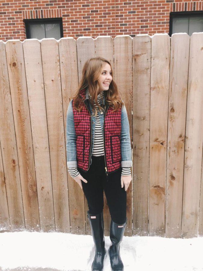 For this look, Emma is wearing a striped long sleeve with a jean jacket and a plaid red and black vest, very seasonal. She is also wearing a pair of black jeans and black tall Hunter boots for the winter time. You can find this look on Fashionablyemma.com 