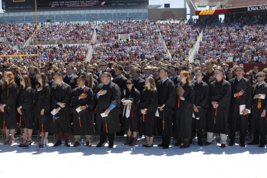 Graduating students rise as the national anthem is performed at the 2017 Iowa State University graduation commencement ceremony. The 2017 class is the largest ever for the university, with over 5,000 students earning degrees.