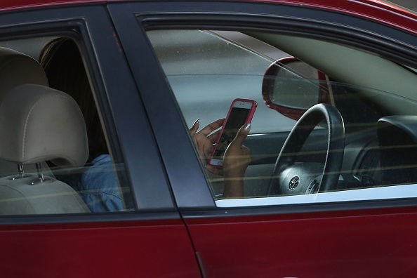 A woman texts while driving.