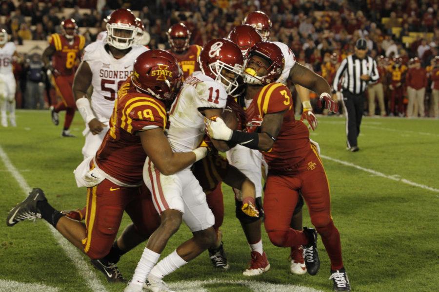 A group of Cyclones including freshmen Mike Johnson and JaQuan Bailey bring down Oklahomas Dede Westbrook.