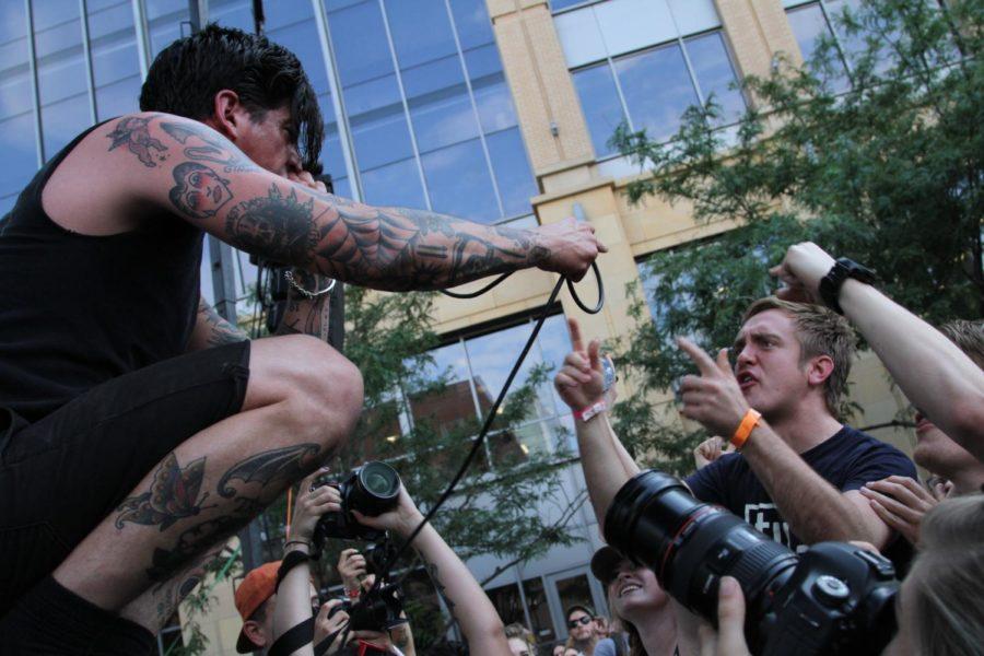 Modern Life is War plays the Kum and Go stage as fans jump towards the microphone. Modern Life is War is a metal group from Des Moines.