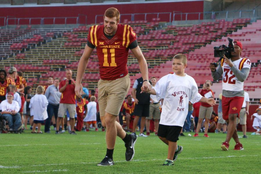 Chase Allen helps Will Munter run in a touchdown during Victory Day on Aug. 25 at Jack Trice Stadium. Victory Day gives children with disabilities the opportunity to meet and participate in drills with Cyclone football players.