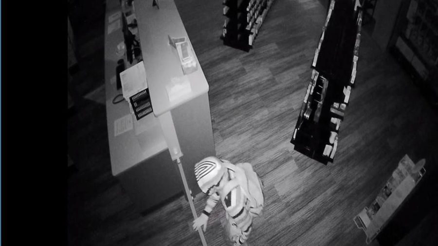 The suspect is pictured robbing the NurCara Pharmacy in Ames. The Ames Police asked the public to help them in identifying the man in this photo.