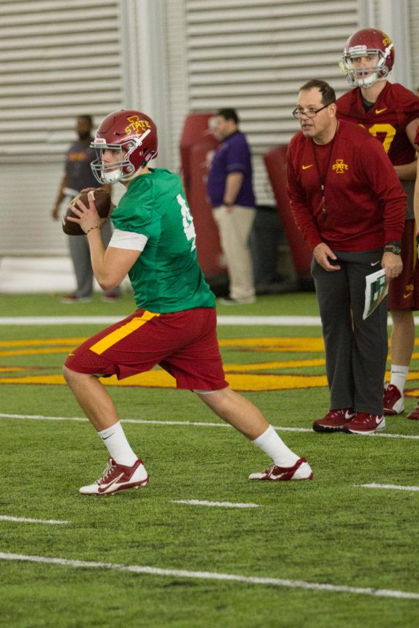 Quarterback Zeb Noland throws a ball downfield as quarterbacks coach Jim Hofer watches during spring football practice March 8 in the Bergstrom Football Complex. 