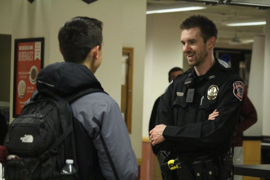 Anthony Greiter, community outreach officer with the Iowa State University Police Department, speaks with a student during their Coffee with Cops event Dec. 7. The event was created to start communication with the community in a positive environment. The event was built on the idea of small town where everyone meets in a coffee shop. Instead of officers meeting the community at traffic stops or during stressful events, the hope with “Coffee with Cops” is that it will bring positive dialogue between the community and police officers. 
