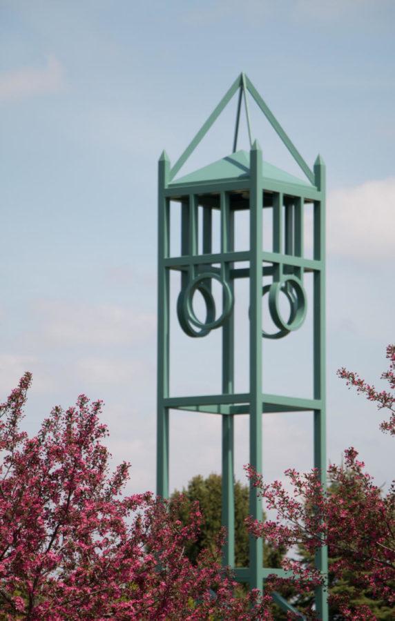 The clock tower at Reiman Gardens stands between two trees in bloom on April 23. 