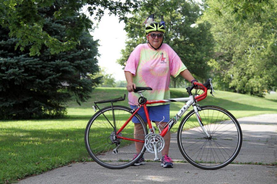 Joyce Bricker stands with her bike across from Hilton Coliseum on Aug. 3.