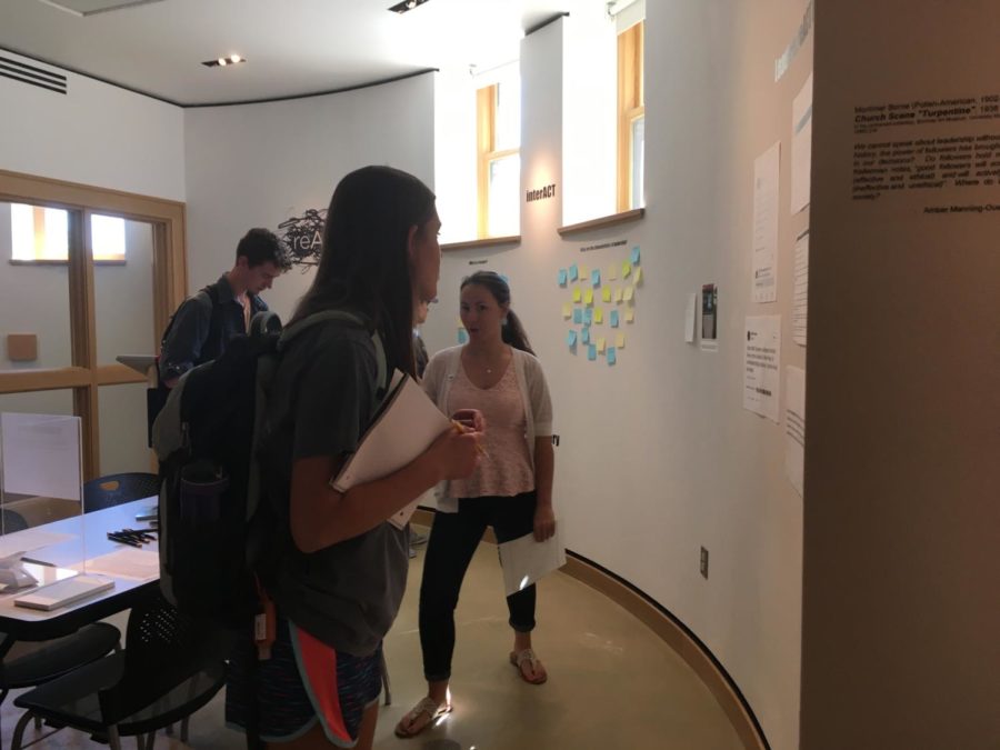 Aspen Pflanz, a senior in history and an intern with University Museums, explains the reACT gallery to students on Friday, September 8. 