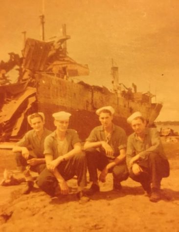Grandpa Ben Visser (second from the left) and some of his shipmates pose in front of the DuPage after Japanese pilots bombed the ship.