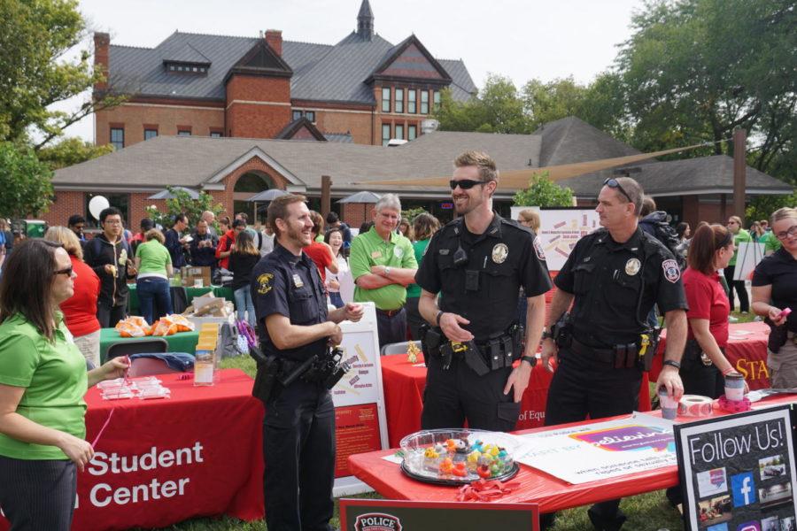Ames Police Officer Eric Snyder, ISUPD officer Anthony Greiter and chief Michael Newton man a display promoting their ‘Start by Believing’ campaign against sexual assault at the Green Dot launch on Sept. 27.