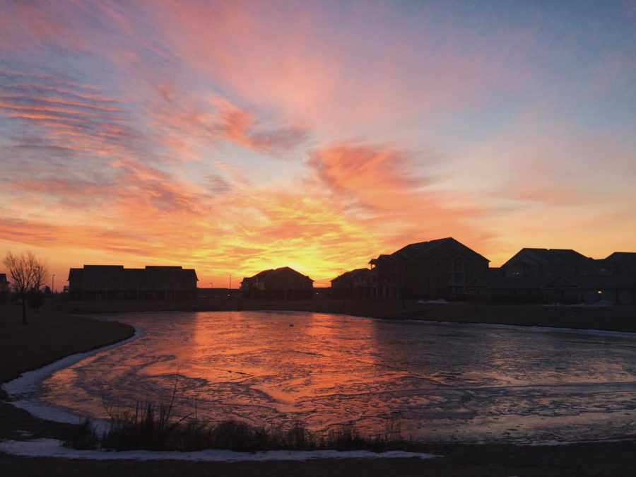 The sun rises over the pond at the Fountain View apartment complex in west Ames. 