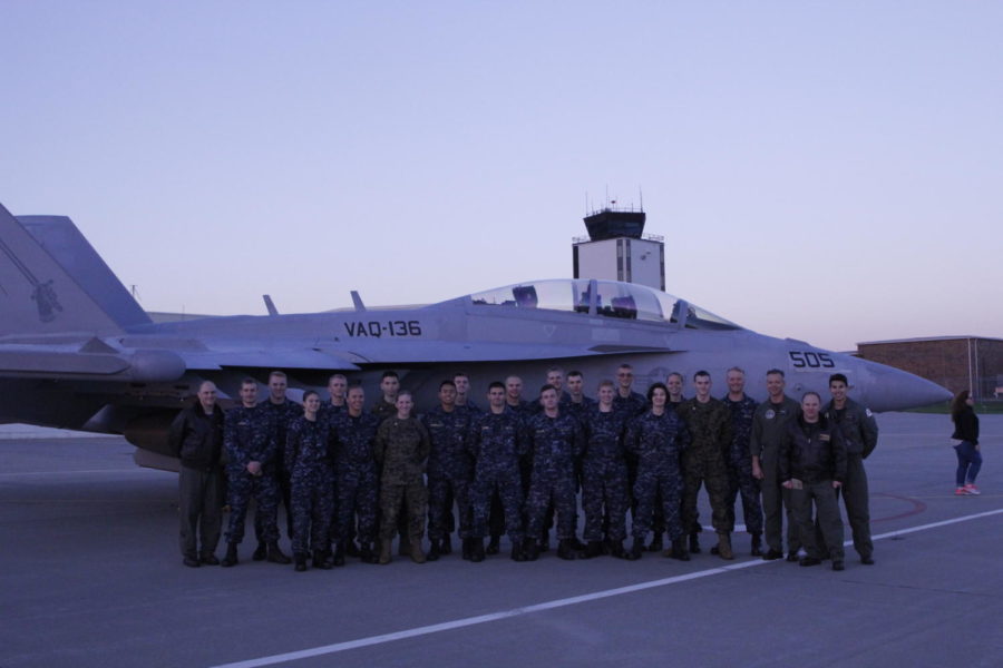 Current Navy ROTC students stand with commanding officers in front of the EA-18G Growler aircraft