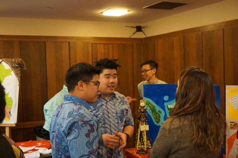 Representatives of Indonesia talk to students about Indonesias culture and way of life. With their knowledge, they display a colorful poster board and many figurines that help represent their culture.