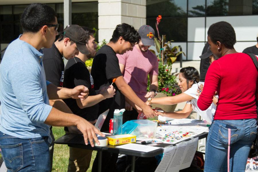 Students sign posters stating I stand with immigrants outside of Parks Library on Oct. 4.