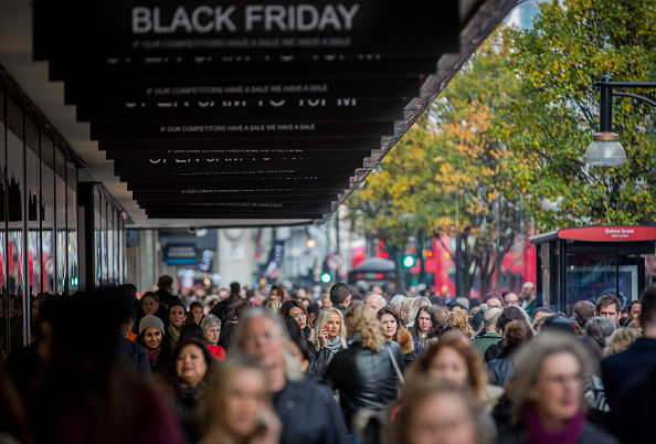 People walk past a shopfront on Oxford Street advertising Black Friday discounts on November 28, 2014 in London, England. Originating in the USA as a sales day that following the Thanksgiving holiday, Black Friday is becoming an increasingly popular shopping day in the UK.