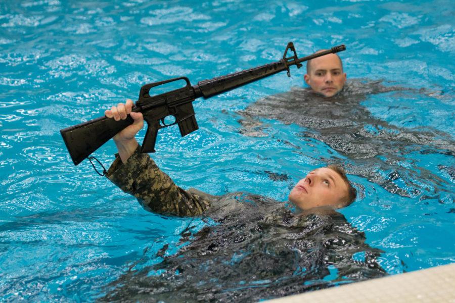 Member of the Iowa state ROTC swims across the pool during Combat Water Survival Training in Beyer Hall Nov. 15. In order to become an officer members of the ROTC must pass the stations consisting of treading water, underwater gear ditch, 15-meter swim with rifle held above water, and jumping off diving board blindfolded also with holding their rifle. 