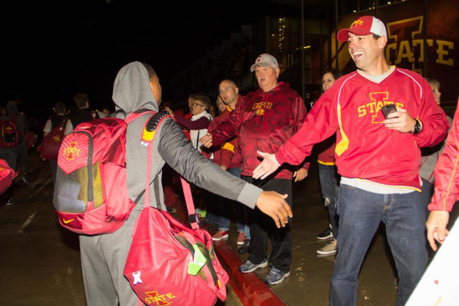 A member of the Iowa State football high fives fans after arriving back in Ames Oct. 7 following the Oklahoma football game where Iowa State defeated Oklahoma 38-31. 