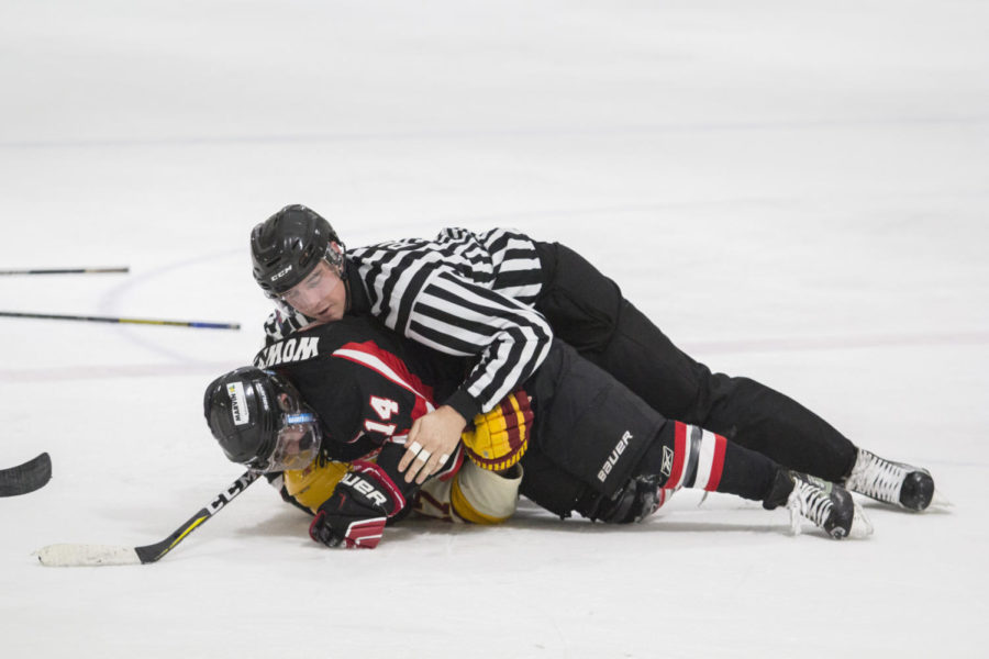 Referee attempts to break up two fighting players Dec. 3 at the Ames Ice Arena during the third period of the Iowa State vs Minot State match up. The Cyclones were defeated by Minot State 4-1.