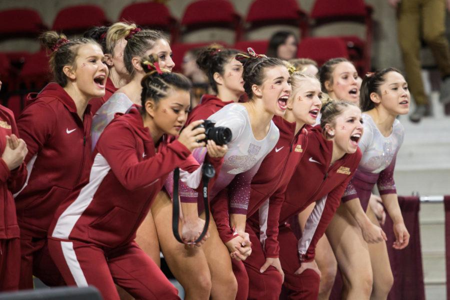 Members of the Iowa State Gymnastics Team cheer after a compleated pass during Senior Hilary Green's floor routine during the Iowa State vs. Texas Woman's University meet Jan. 26. The Cyclones defeated the Pioneers 195.275 to 191.050.