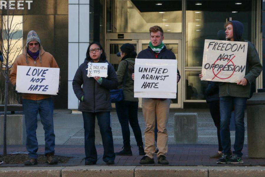 Demonstrators hold signs in front of the Neal Smith Federal Building for the Iowans Need Your Help: Rally To Support Dreamers and TPS Holders on Dec. 1, 2017. About 50 people attended the event.