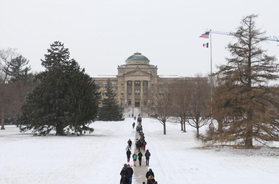 Students+walk+between+Curtiss+and+Beardshear+halls+during+a+snowstorm+on+Jan.+11%2C+2018.+Despite+a+12-hour+winter+weather+advisory%2C+the+university+remained+open.