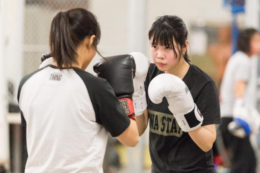 Senior Xin Long works on combination drills with senior Ye-Lim Lim Jan. 16. during Cyclone Boxing Club practice in the basement of State Gym. 