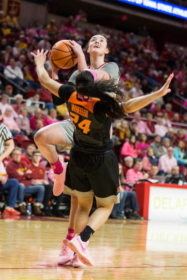 Senior guard Emily Durr Knocks and Oklahoma State player to the ground while going up for a basket during the Iowa State vs OSU basketball game Feb. 10 in Hilton Coliseum.The cyclones were narrowly defeated by the Cowgirls 73-81