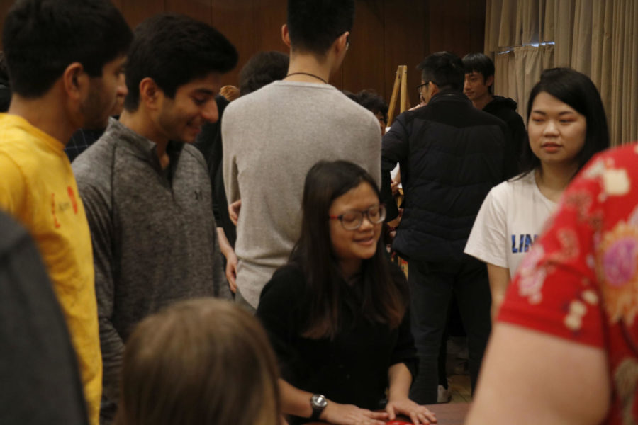 Participants gather around the table to play Dun! which includes squatting without hesitation. The games were played in the Memorial Union as a part of the Lunar New Year Celebration on Feb. 18.