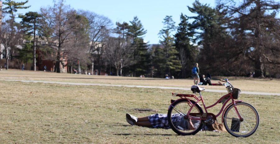 A student dozes off next to their bicycle.