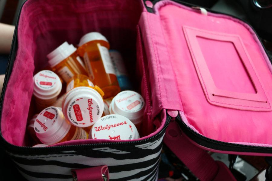 Over a dozen of Scarlett Eagles orange prescription bottles are housed in a pink and zebra-striped lunchbox. Eagle has Ehlers-Danlos Syndrome, hypermobility type, which causes chronic pain in the joints. Although she swears its a coincidence, its fitting, given that many people with EDS identify themselves as zebras.