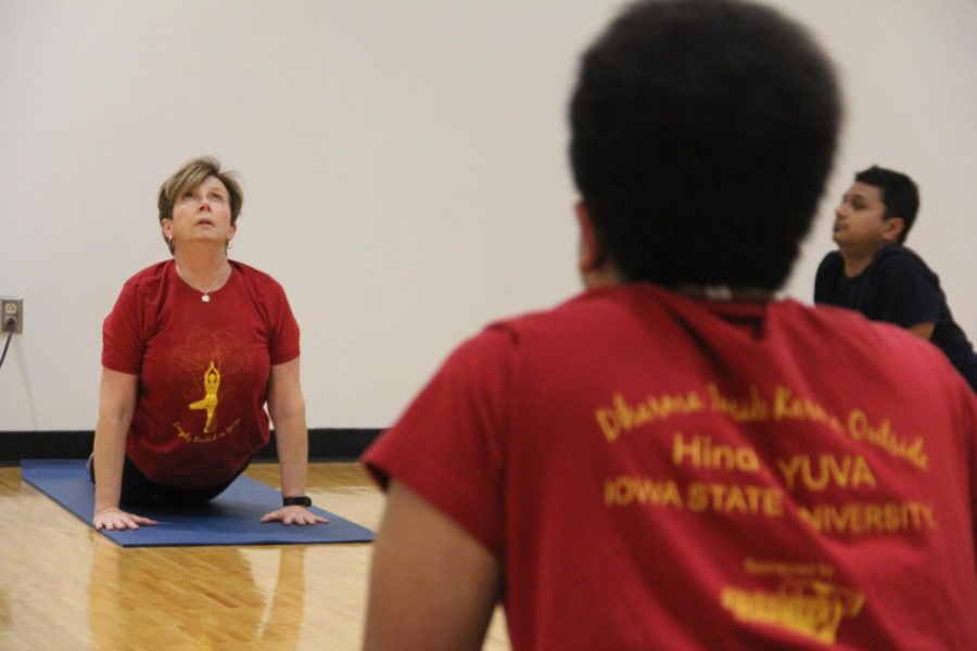 Nora Hudson, program coordinator for Recreation Services and a collaborator with Hindu YUVA, performs a cobra position at State Gym on Jan. 26.