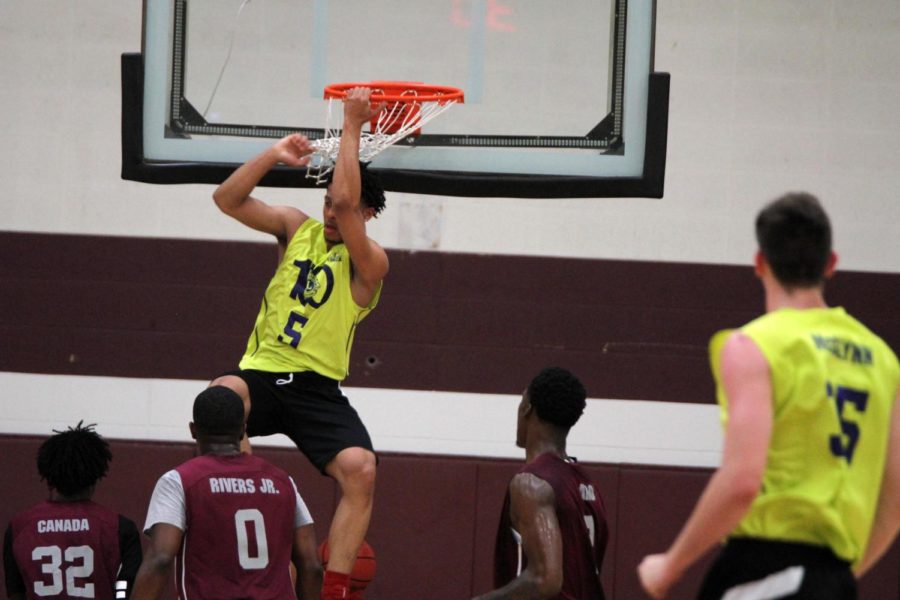 Lindell Wigginton hangs from the rim after dunking during Thursday nights Capitol City League game in Ankeny.