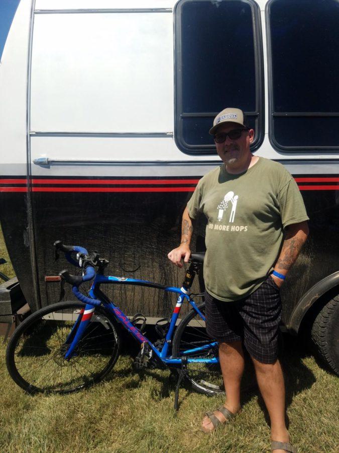 Jon Wolgamuth in front of his bike and car used to shuttle and support family.