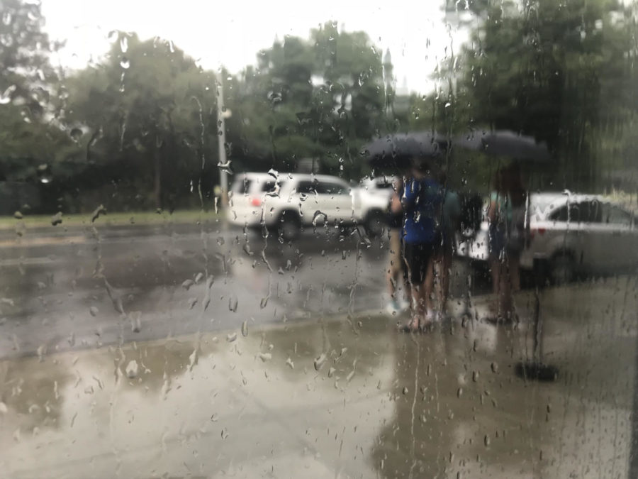 Students stand outside in the rain along Lincoln Way on Thursday, Aug. 16, 2018. 