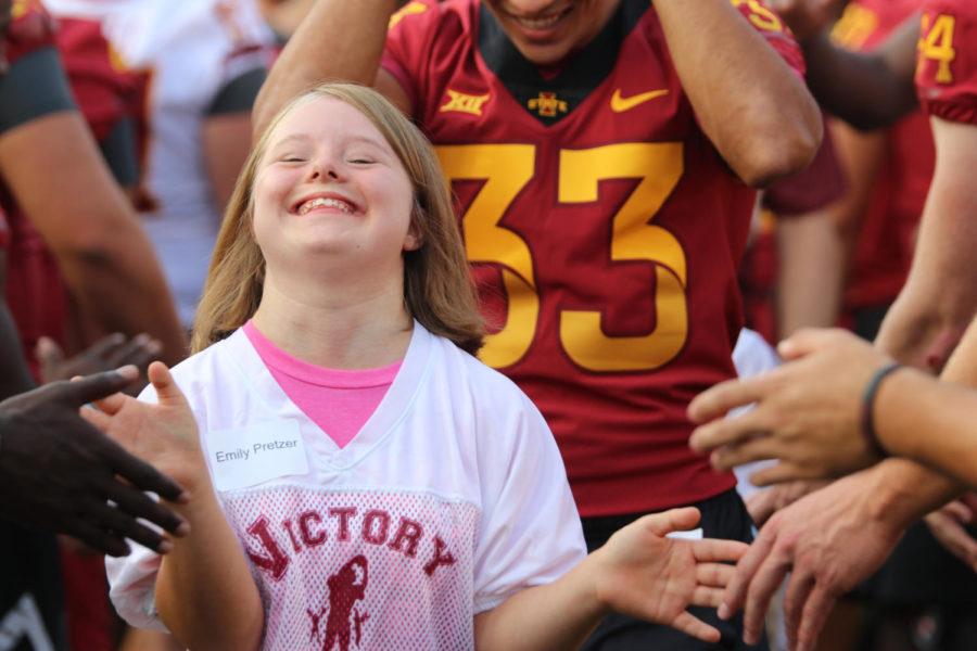 Emily Pretzer walks through a tunnel of Cyclone football players during the opening of Victory Day Aug. 24 at Jack Trice Stadium. Victory Day gives local children with disabilities the opportunity to meet and play with members of the Iowa State football team.
