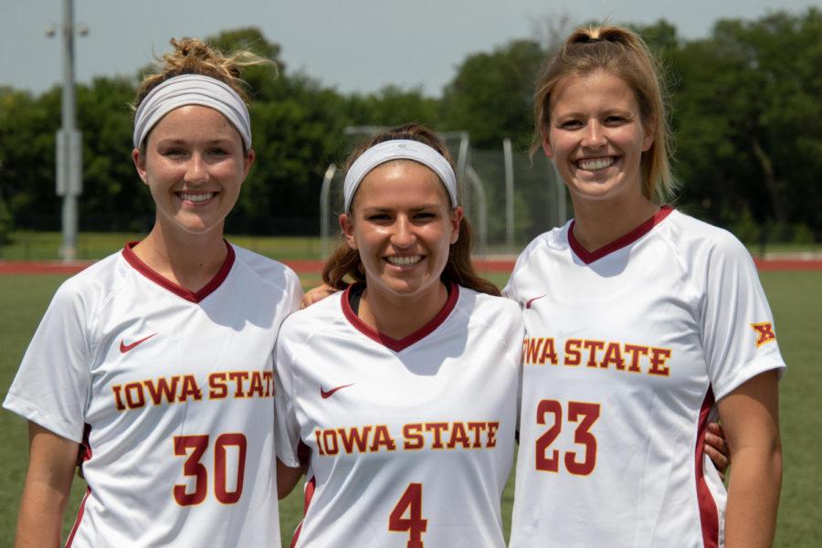 Riley Behan (left), Emily Steil and Jordan Enga pose at media day on Aug. 3.