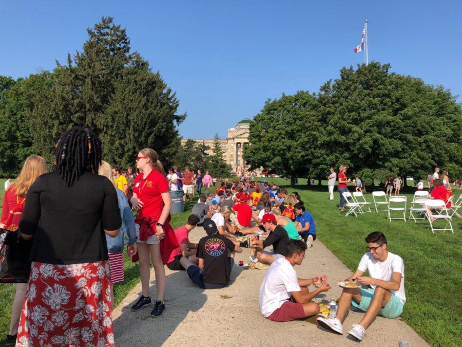 Incoming Freshman sit in clusters on Central Campus while eating pancakes during Destination Iowa State Aug. 17.