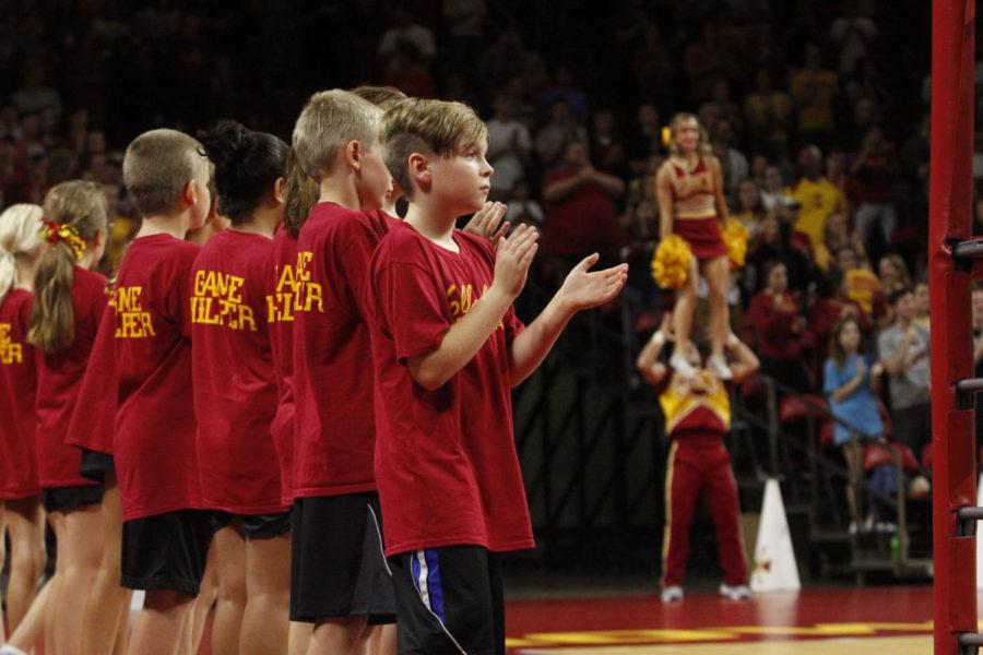 A game helper cheers as the Cyclones volleyball team enters Hilton Coliseum on Aug. 24. 